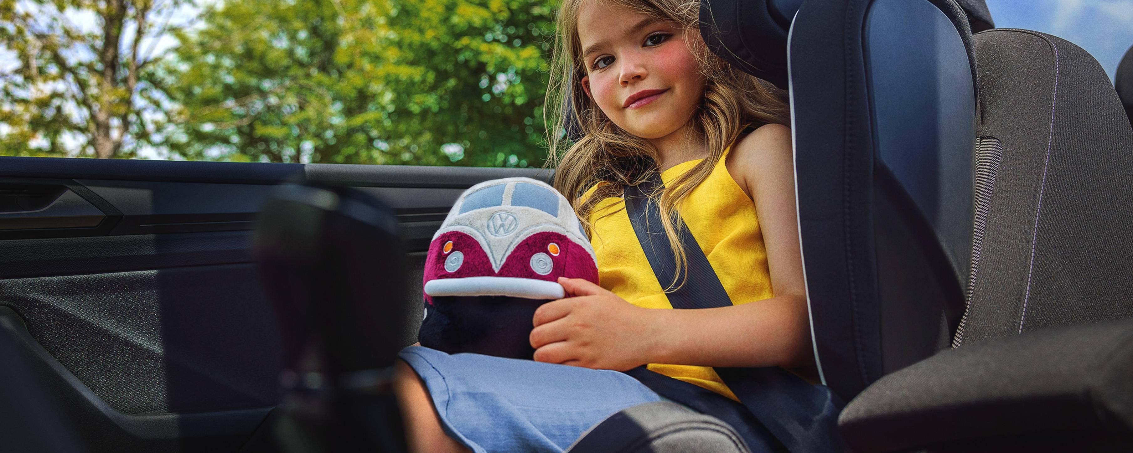 Dziewczynka z pluszowym samochodzikiem w aucie.
